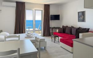 a living room with a red couch and the ocean at Open Sea Apartments in Utjeha +122 photos