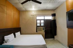 una piccola camera da letto con un letto e una finestra di Hotel O Gold Inn a Faridabad Altre 20 foto