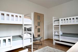 a room with three bunk beds and a chair at Pool & Relax Mukařov in Srbín +54 photos