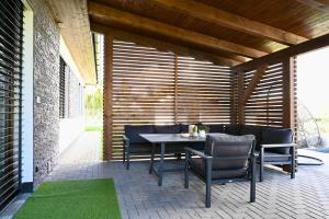 a patio with a table and chairs on it at Pool & Relax Mukařov in Srbín