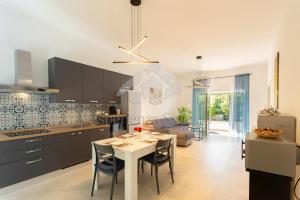 eine Küche und ein Wohnzimmer mit Tisch und Stühlen in der Unterkunft Villa Natura - Deluxe in Neviano