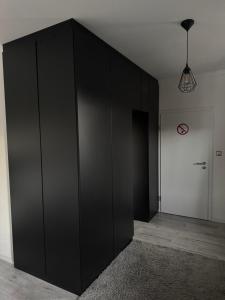 a large black cabinet in a room with a door at Studio am Waldrand in Bad Hersfeld