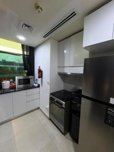 een keuken met een koelkast en een magnetron bij Nuchiii Hostel in Dubai