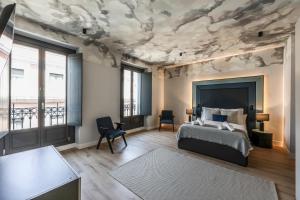 a bedroom with a bed and a ceiling with clouds at AmazINN Collection Madrid Plaza Mayor in Madrid