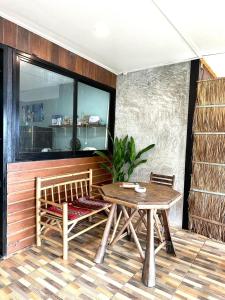 eine Terrasse mit einem Holztisch und einer Bank in der Unterkunft House Sea Front view - Swimming Pool in Ko Chang