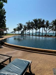 a large swimming pool with palm trees and the ocean at House Sea Front view - Swimming Pool in Ko Chang +11 photos