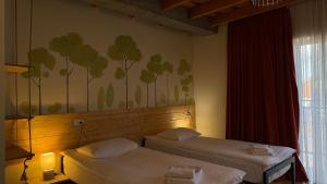 a room with two beds and a painting on the wall at Hotel Ailama Mestia in Mestia