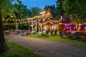 ein mit Lichtern bedecktes Gebäude mit Tischen und Stühlen in der Unterkunft KNAUS Campingpark Leipzig in Leipzig
