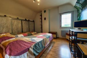 a bedroom with a bed and a desk with a computer at TY Lavarion in Le Bono