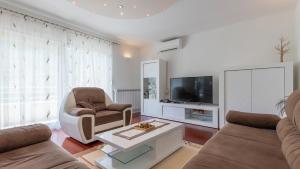 a living room with a couch and a tv at Villa Rusula -Makarska by Villas Guide in Zagvozd