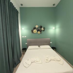 une chambre avec un lit avec deux pantoufles dessus dans l'établissement Don Armando al Massimo, à Palerme