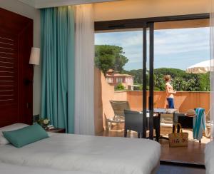 ein Hotelzimmer mit Bett und Balkonblick in der Unterkunft Hôtel Les Jardins De Sainte-Maxime in Sainte-Maxime