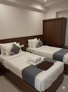 two beds in a hotel room withskirts at Hanuman Heritage in Chikmagalūr +4 photos