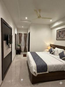 a bedroom with a bed and a flat screen tv at Hanuman Heritage in Chikmagalūr