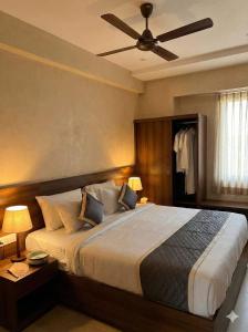 a bedroom with a large bed with a ceiling fan at Hanuman Heritage in Chikmagalūr