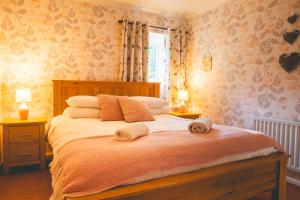een slaapkamer met een bed met twee handdoeken erop bij Langriggs at Wetheral Cottages in Great Salkeld