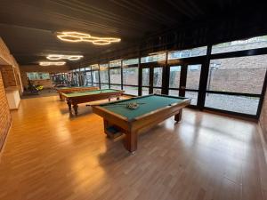 three pool tables in a room with windows at D'Acosta Hotel Belencito in Nobsa
