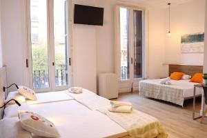 a room with two beds and a flat screen tv at lullaby by hamilton in Barcelona