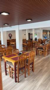 una sala da pranzo con tavoli e sedie in legno di Hotel La Roza e Restaurante Grill a Penha