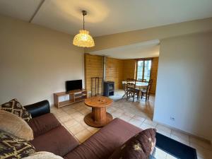 een woonkamer met een bank en een tafel bij Maison du Verger Idéal pour séjours pros in La Rochefoulques