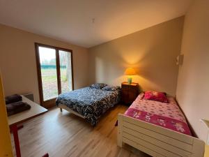 een slaapkamer met twee bedden en een raam bij Maison du Verger Idéal pour séjours pros in La Rochefoulques