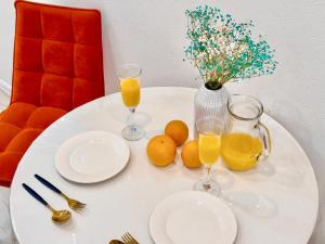 a white table with oranges and glasses of orange juice at ЖК Абая 5 in Kokshetau