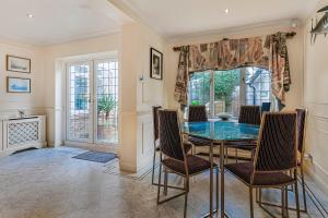 a dining room with a glass table and chairs at Sobo House in Southbourne