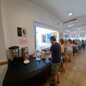 a group of people standing at a counter in a restaurant at Hotel Confianza in Corrientes +15 photos