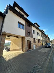 een gebouw met een garage met een auto ernaast bij Panorama 79 in Nowy Targ