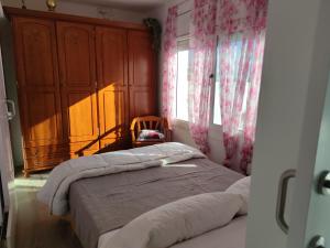 ein Schlafzimmer mit einem Bett, einer Kommode und einem Fenster in der Unterkunft Suite de invitados independiente in Cerdanyola del Valles