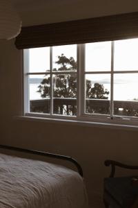 a bedroom with a window with a view of the ocean at Gills in Murdunna