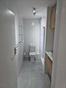 a white bathroom with a toilet and a sink at Laguna Grove 20 in Knysna
