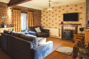un soggiorno con divano e camino di Windale at Wetheral Cottages a Great Salkeld