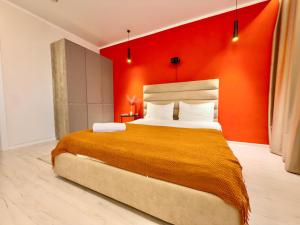 a bedroom with a large bed with an orange wall at ЖК Абая 5 in Kokshetau