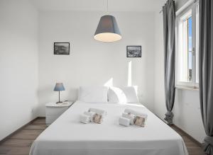 una camera da letto bianca con un letto bianco e una finestra di Balcone Sul Centro Storico Ac Wi-Fi Parcheggio ad Ancona