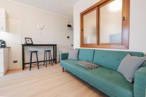 a living room with a green couch and a table at V-Home Holiday Moro 60 in Grassobbio