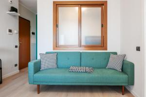 a green couch in a room with a window at V-Home Holiday Moro 60 in Grassobbio +19 photos