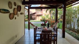een eetkamer met een tafel en stoelen op een terras bij Casa 4 Quartos 2 Quadras da Praia Com Roupa Cama in Porto Seguro