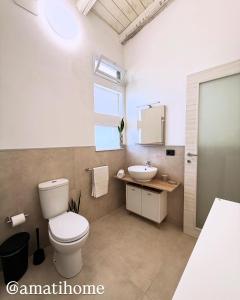 a bathroom with a toilet and a sink at Amati home in Floridia +28 photos