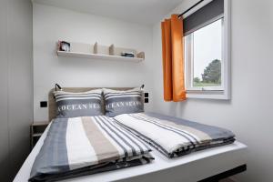 een slaapkamer met een bed en een raam bij KNAUS Campingpark Meppen in Meppen
