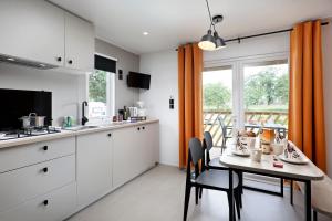 een keuken met witte kasten en een tafel met stoelen bij KNAUS Campingpark Meppen in Meppen