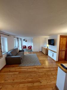 een woonkamer met een bank en een televisie bij Lo Reinard in Nus