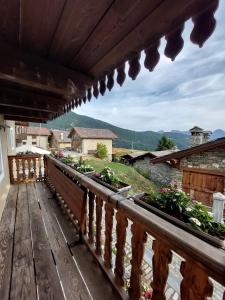 een balkon met een houten balustrade met bloemen erop bij Lo Reinard in Nus