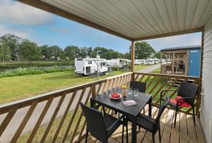 een balkon met een tafel en stoelen en een camper bij KNAUS Campingpark Meppen in Meppen