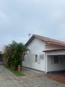 ein weißes Haus mit einer Palme davor in der Unterkunft Almeida dos camaroes in Cabo Frio