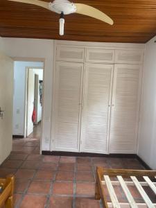 ein Raum mit weißen Schränken und einem Deckenventilator in der Unterkunft Almeida dos camaroes in Cabo Frio