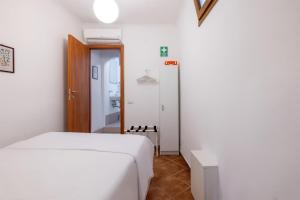 a white bedroom with a bed and a hallway at La Casetta di Via Sannio in Rome