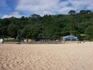 a group of people on a beach with trees in the background at Fairholme in Dartmouth