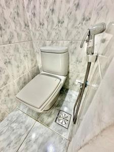 ein weißes WC im Bad mit Marmorwänden in der Unterkunft Duplex de Frente para a Praia - Angra Inn in Angra dos Reis