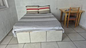 a bed in a room with a table and a chair at Pousada Gaúcha Caibi in São Domingos